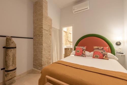 1 dormitorio con 1 cama con cabecero verde en Angeles 6- Giralda Luxury by Valcambre, en Sevilla
