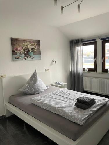a white bedroom with a large bed and a window at Zum Deutschen Heinrich in Gifhorn