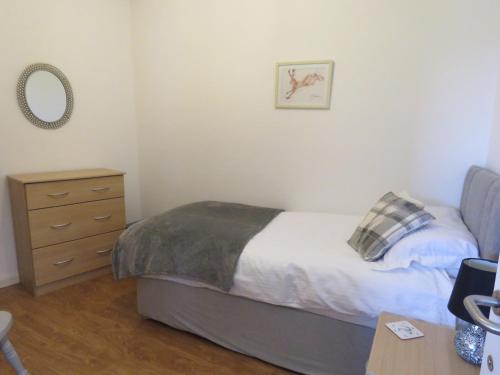a bedroom with a bed and a dresser at Beautiful 3-Bed Cottage in Llancarfan Nr Cardiff in Barry