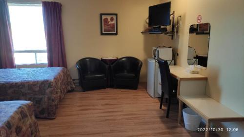 a hotel room with a bed and a desk and chairs at Motel Rayalco in Laurier Station