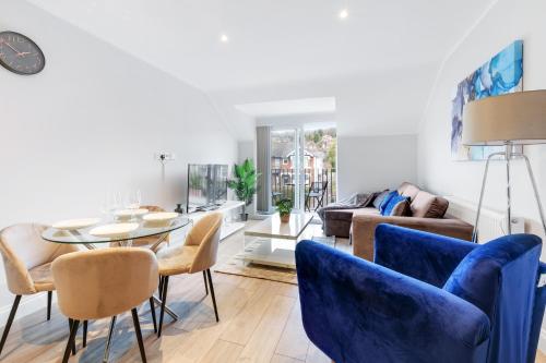 a living room with blue chairs and a table at The Modern Apartments - 2 Bedroom with Parking by 360Stays in High Wycombe