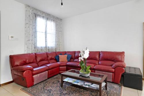 a red leather couch in a living room with a table at La Villa in Mantova