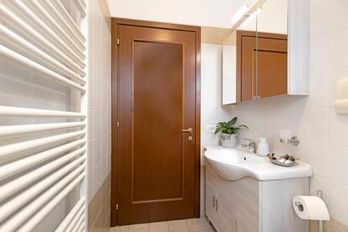 a bathroom with a sink and a wooden door at La Villa in Mantova