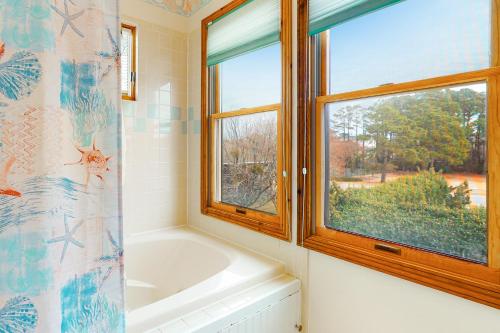baño con bañera y ventana en Crustacean Sensation CL12 en Corolla