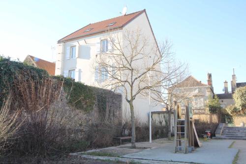 a house with a tree and a ladder in front of it at La Source aux Cépages in Santenay