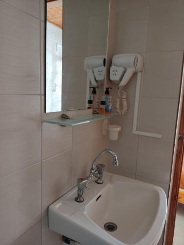 a bathroom with a sink and a mirror at Kissandros Hotel in Agia Galini