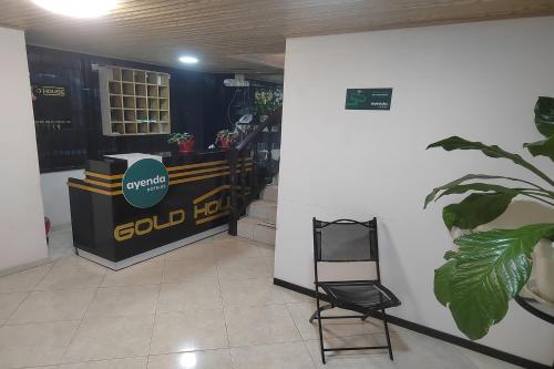una habitación con un cartel en la pared y una silla en Ayenda Gold House, en Bogotá