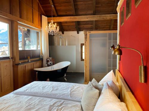 a bedroom with a bed and a tub in a room at Panorama Chalet Heimatliebe in Ladis