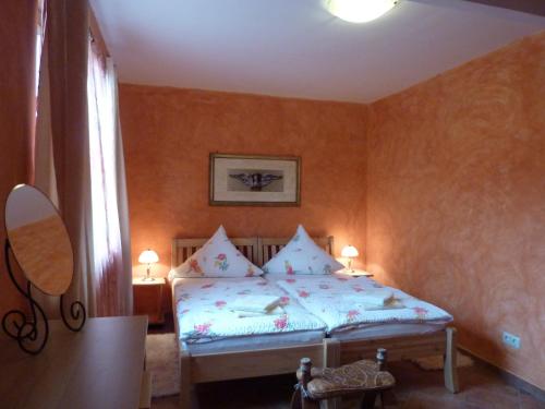 a bedroom with a bed in a room with orange walls at Ferienwohnung Haus am Singberg in Ramsthal