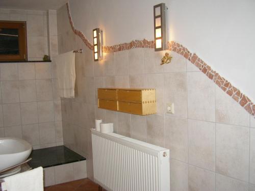 a bathroom with a sink and a toilet and lights at Ferienwohnung Haus am Singberg in Ramsthal