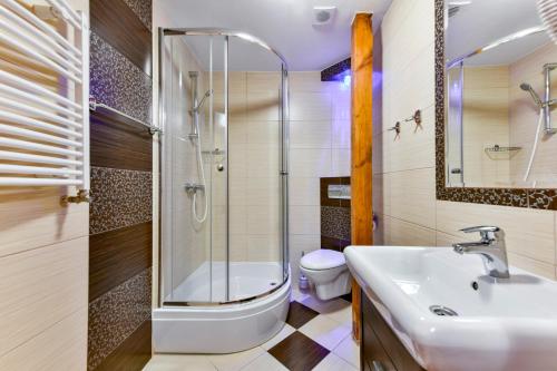 a bathroom with a sink and a toilet and a shower at Ośrodek Rekreacyjny Aga in Gąski