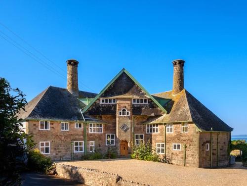 a large brick house with two chimneys on top at The Beach House-Devon- On the beach- sleeps 20 in Exmouth
