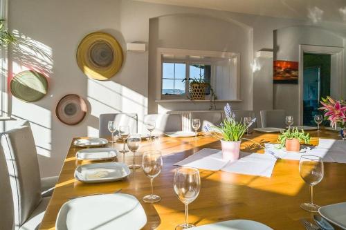 a dining room with a wooden table with wine glasses at The Beach House-Devon- On the beach- sleeps 20 in Exmouth