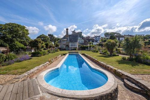 a large swimming pool in front of a house at The Beach House-Devon- On the beach- sleeps 20 in Exmouth