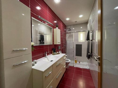 La salle de bains est pourvue d'un lavabo, de toilettes et de carrelage rouge. dans l'établissement Ucha Villa, à Barcelos