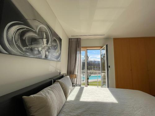 a bedroom with a bed with a picture on the wall at Ucha Villa in Barcelos