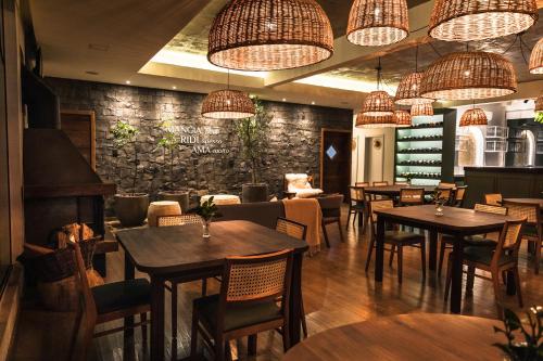 a restaurant with tables and chairs and chandeliers at Pousada Cantelli in Bento Gonçalves