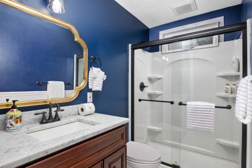 a bathroom with a sink and a glass shower at Tulip Street Retreat in Eugene
