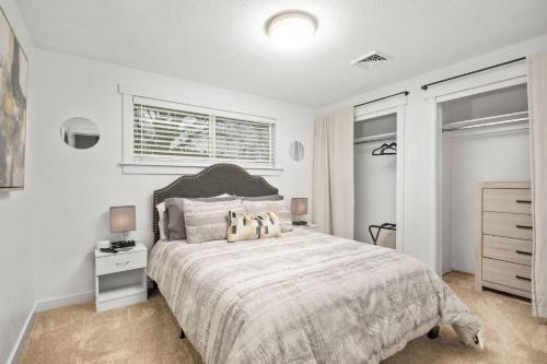 a white bedroom with a large bed and a window at Tulip Street Retreat in Eugene