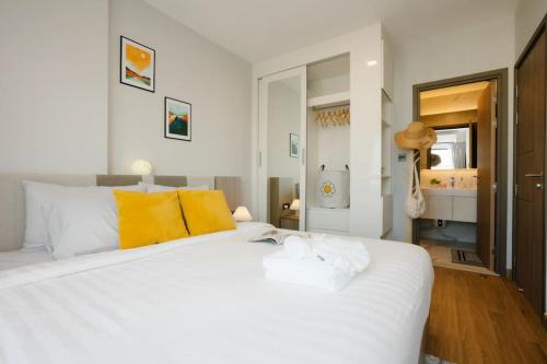 - une chambre avec un grand lit blanc et des oreillers jaunes dans l'établissement Sky River, Luxury Infinity, Center Chiang Mai, à Chiang Mai