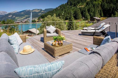 a living room with a couch and chairs on a deck at Chalet Ruisselet - OVO Network in Châtel