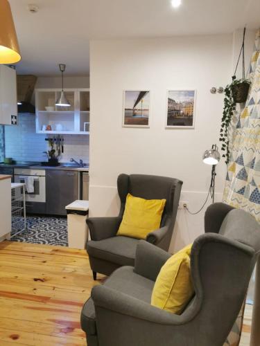 a living room with two chairs and a kitchen at 262 Baixa Guesthouse in Lisbon