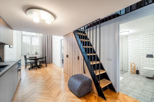 a kitchen and dining room with a staircase in a house at Downtown Ministery - luxury apartments in the Heart of the City in Kaunas