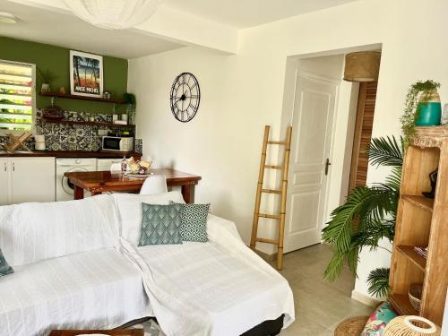 ein Wohnzimmer mit einem Sofa und einer Uhr an der Wand in der Unterkunft Ti Kay Ilets in Les Trois-Îlets