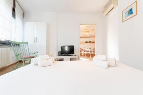 a white bedroom with a large bed and two chairs at Marcona Apartment in Milan
