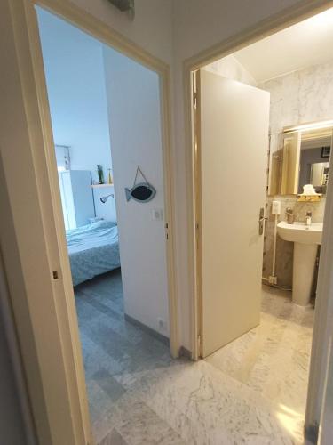 a bathroom with a door open to a room with a sink at Tribuperez à Juan-Antibes in Juan-les-Pins