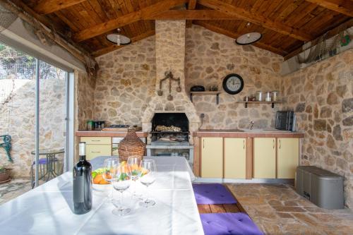 eine Küche mit einem Tisch und Weingläsern darauf in der Unterkunft Villa Mimosa in Novalja