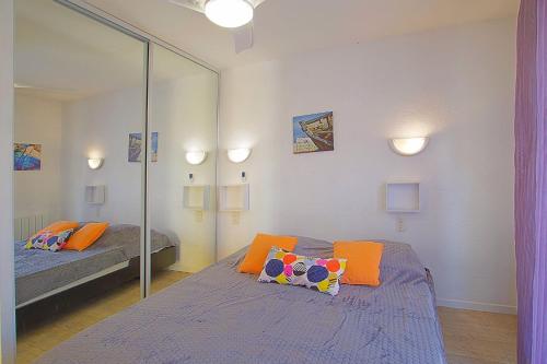 una camera con due letti e uno specchio di Appartement Terrasse vue Mer a Canet-en-Roussillon