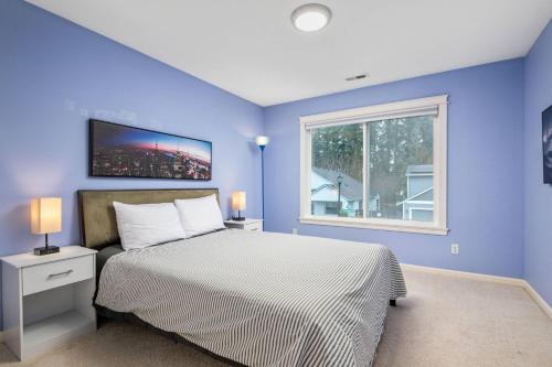 a blue bedroom with a bed and a window at Seiben Creek Retreat in Clackamas