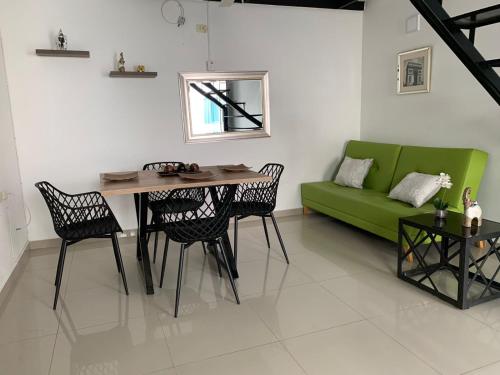 uma sala de estar com um sofá verde e uma mesa em CIC Apartamento amoblado Mirador del Sinú em Montería