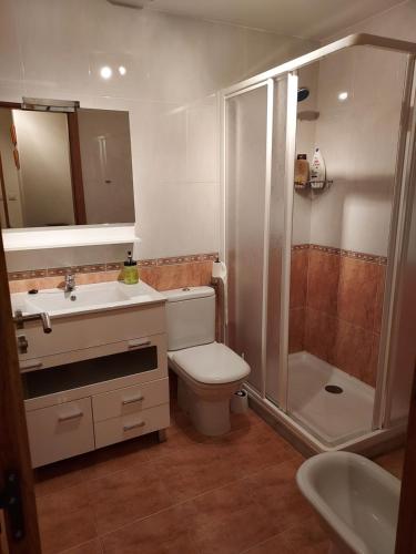 a bathroom with a toilet and a shower and a sink at Apartamento con jardín in Lira