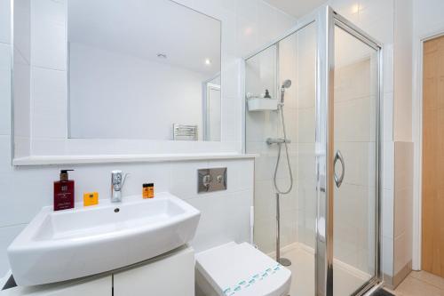 a white bathroom with a sink and a shower at D8 - Canal View Apartment in London