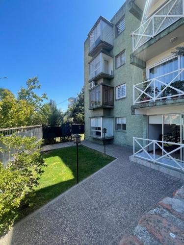 an apartment building with a lawn in front of it at Hermoso Depto Terraza in Rancagua