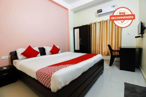 1 dormitorio con 1 cama grande con almohadas rojas en Aditya Guest House, en Dispur