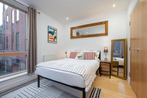 a bedroom with a bed and a large window at D8 - Canal View Apartment in London