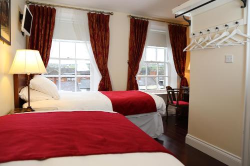Habitación de hotel con 2 camas y ventana en Number 8 The Townhouse, en Derry Londonderry