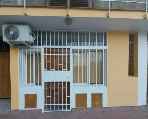 a building with barred doors and a fan at Mendoza Alquileres D10 in Ciudad Lujan de Cuyo