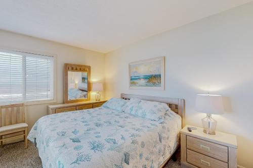 a bedroom with a bed with a blue comforter at Docktor's Oarders 180 RR in Rodanthe