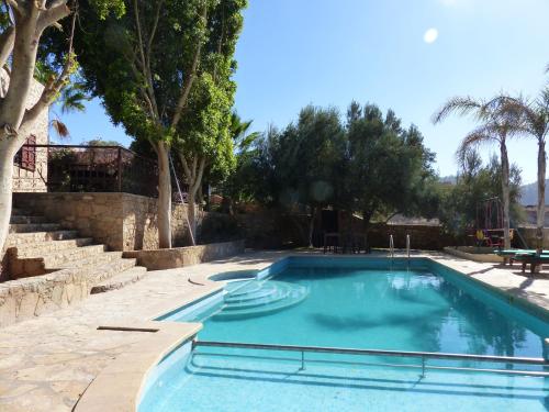 Agadir-Taghazout Magnifique Villa Dar Lina 4 etoiles في أغادير: مسبح في ساحه فيها اشجار