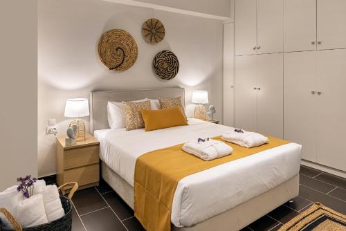 a bedroom with a large bed with two towels on it at Grammata Suites in Ermoupoli