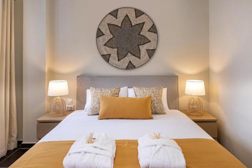a bedroom with a bed with two towels at Grammata Suites in Ermoupoli