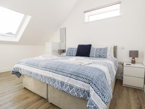 una camera da letto con un grande letto con un piumone blu e bianco di The Crest a Helston