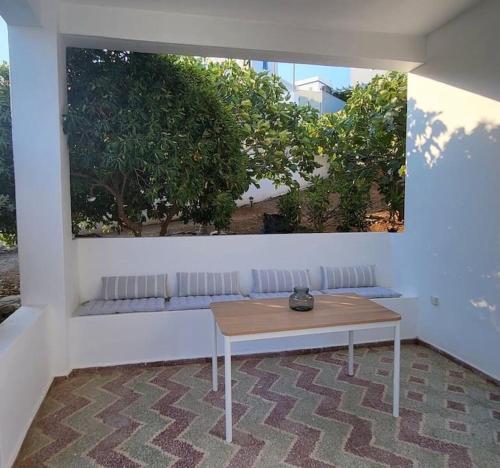 a white room with a table and a bench at Alegria in Posidhonía