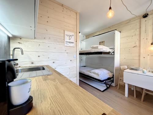 - une cuisine avec un évier et des lits superposés dans l'établissement Superbe studio refait à neuf et tout équipé avec parking, à Chamonix-Mont-Blanc
