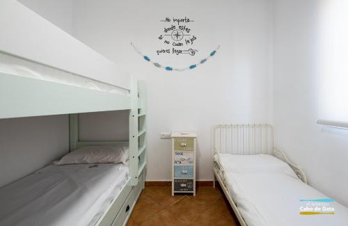 Habitación con 2 literas y reloj en la pared en Apartamento Peñón Blanco, en La Isleta del Moro