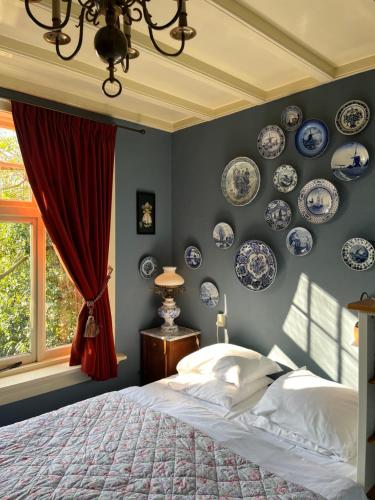 une chambre avec des assiettes bleues et blanches sur le mur dans l'établissement Deventer Heritage en Boutique B&B, museumhuis "De Worp", het huis met de theekoepel, logeren in authentiek historisch erfgoed, à Deventer